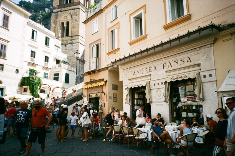 a group of people sitting at tables in front of a building